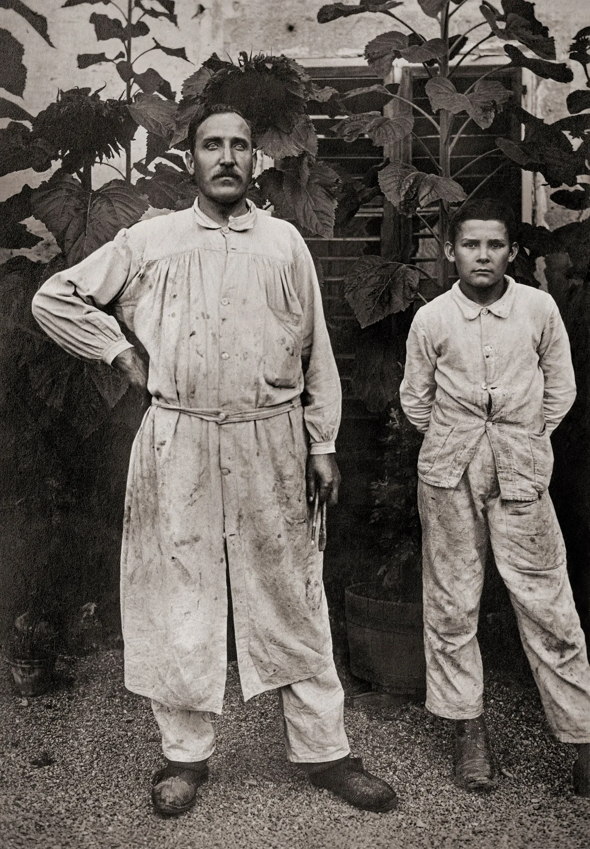 Ein Maler und sein Sohn posieren für ein Foto. Das Bild ist um 1920 entstanden und ist schwarz-weiss.